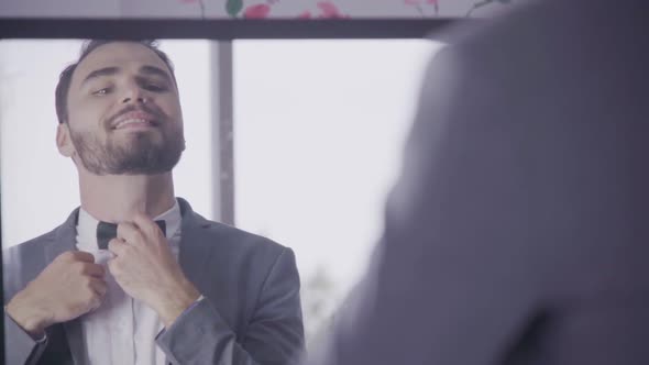 Man in Formal Suit Getting Dressed in Dressing Room for Work or Wedding alt