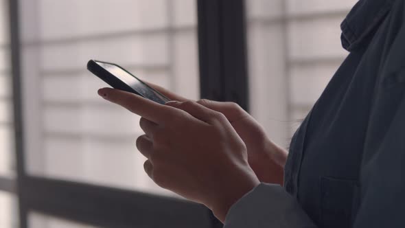 Close up hands young Asian businesswoman holding typing mobile phone.