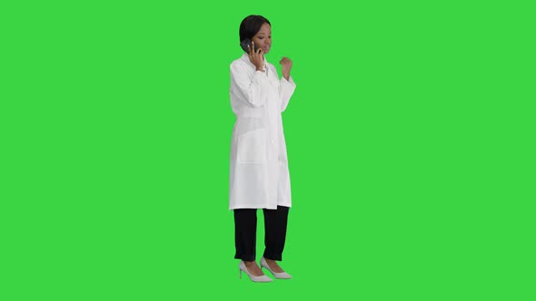 African American Female Doctor Talking on the Phone on a Green Screen, Chroma Key. alt