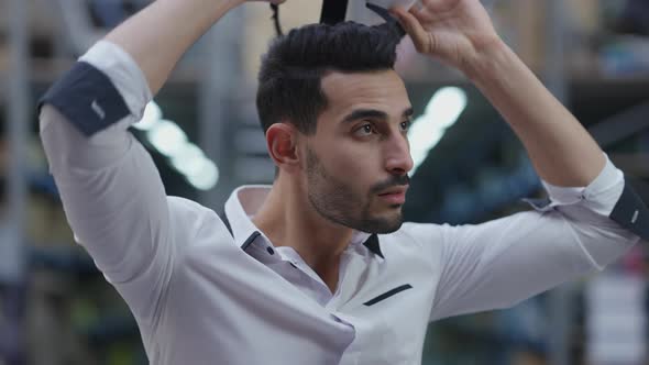 Middle Eastern Man Taking Off VR Headset Admiring Variety of Goods on Racks in Industrial Warehouse alt