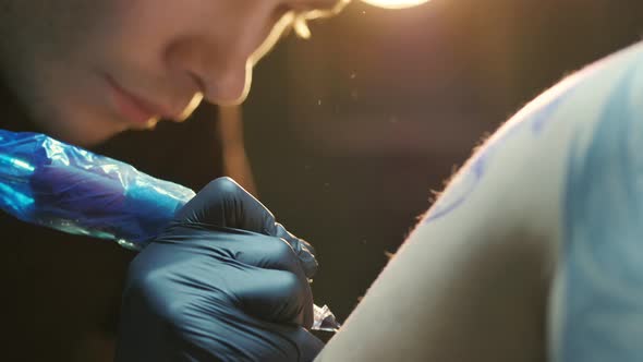 Close Shot of Working Tattoo Artist with Covered in Gloves Hands for Precaution