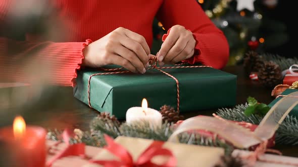 Young woman wrapping Christmas gift box