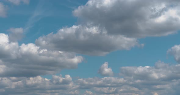 White Puffy Clouds Drifting Across Blue Sky in Time Lapse
