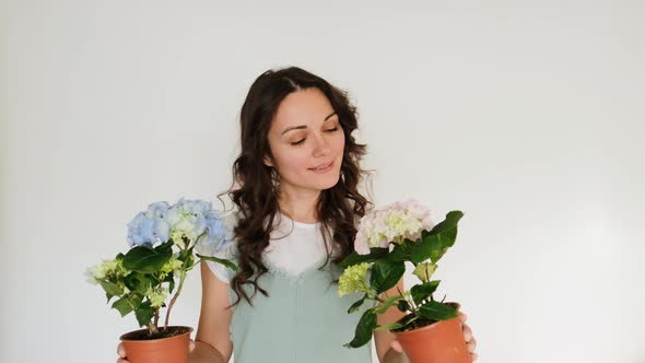 Beautiful Young Woman Florist with Flowers on White Background Smiling at Camera alt