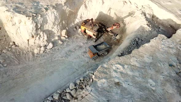 Aerial view of opencast mining quarry with lots of machinery at work - view from above alt