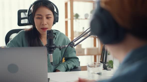 Asia girl radio host record podcast use microphone wear headphone interview celebrity guest content.