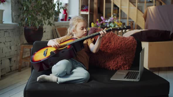 A Girl Learns to Play the Guitar on Her Own Using the Internet alt