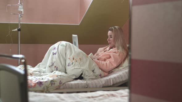 Patient Using Digital Tablet in Hospital Bed alt