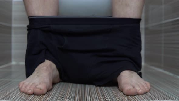 The Man Took Off His Black Panties While Sitting on the Toilet. A Man with Hairy Legs in the Toilet alt