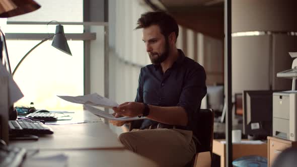 Salesman Analyzing Charts On Laptop.Focused Trader Reading Corporate Financial Audit Report Document alt