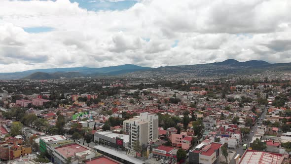 Aerial panoramic view of southern Mexico City. Drone flying backwards and slowly descending with vie alt