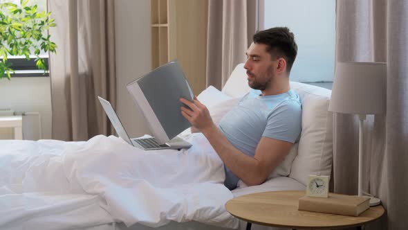 Man with Laptop Working in Bed at Home Bedroom