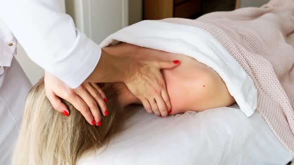 Relaxed woman receiving neck cervical spine massage in aesthetic salon alt