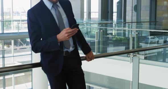 Businessman using smartphone in modern office building alt
