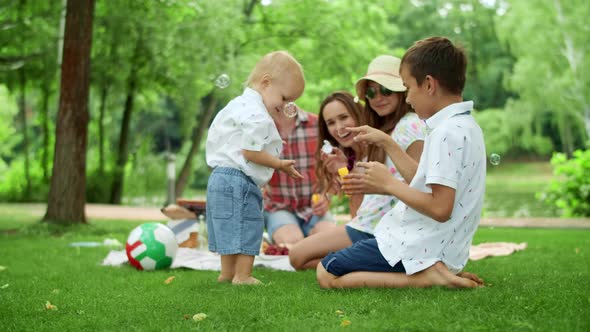 Parents Laughing Together with Kids Outdoors. Family Spending Weekend in Forest alt