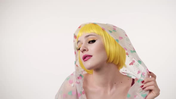 Closeup portrait of woman with colourful makeup in futuristic style wearing yellow wig alt