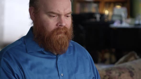 Man looking sad as he puts his hand on his face alt