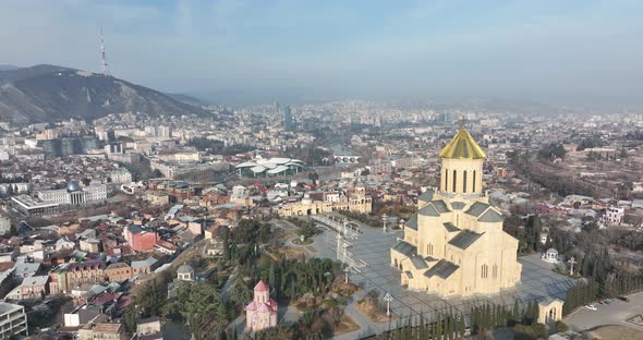 Aerial view of Holy Trinity Cathedral Sameba in Tbilisi Georgia. Sunrise drone footage. alt