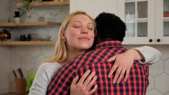 Smiling Caucasian Woman Girlfriend Hugs African American Man Boyfriend at Home alt