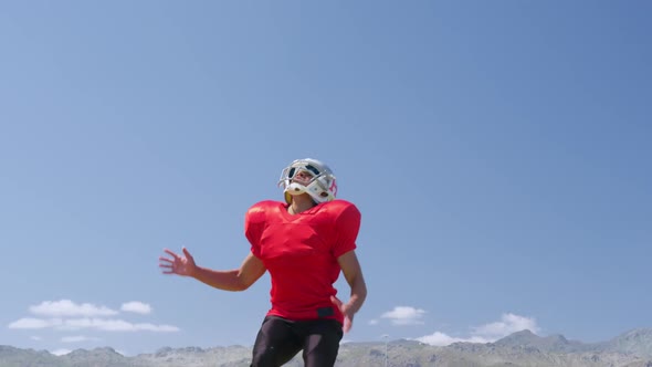 American football player jumping to catch a ball alt