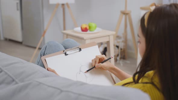 Asian young talented woman artist drawing picture on painting board. alt