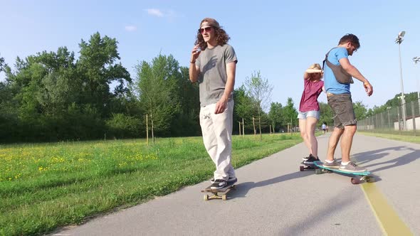 Three cool friends having fun skateboarding alt