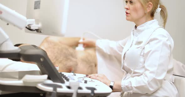 Doctor Examining Males Kedneys with Ultrasound Scan in Clinic alt