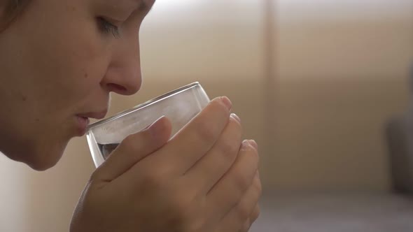 Tea drinking  from the glass slow motion 1920X1080 HD video - Blond modern woman drinks warm liquid  alt
