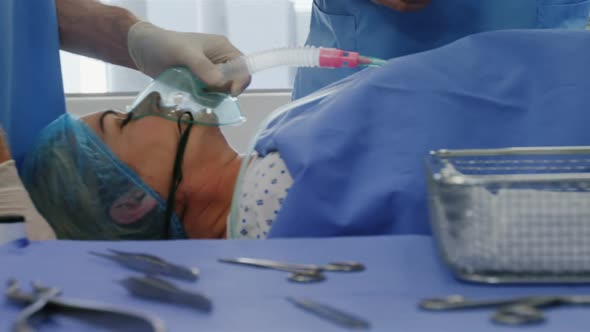 A Caucasian female patient lying on a surgical table during surgery in a hospital operating theatre alt