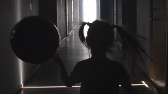 Silhouette of Little Girl with Balloon Running along Hallway