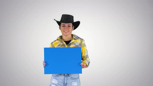 Smiling Pretty Cowgirl Holding Empty Board and Dancing on Gradient Background. alt