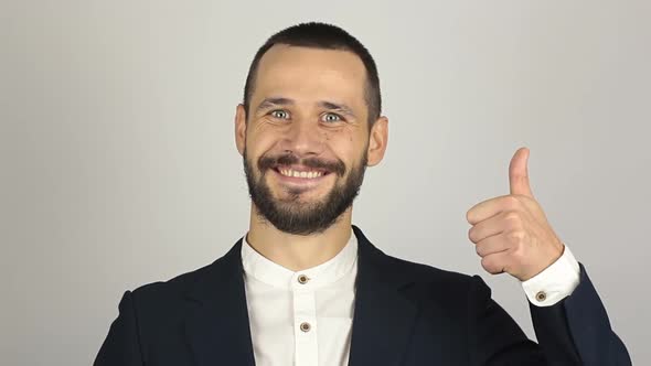 Young Handsome Businessman Is Smiling and Showing Thumb Up with Two Hands