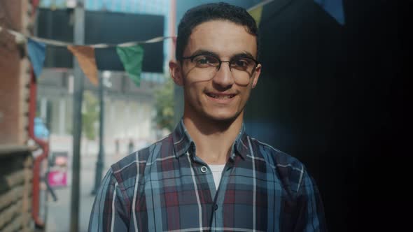 Portrait of Cheerful Arab Man Looking at Camera with Happy Smile Standing Outdoors Alone alt