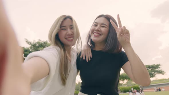 Young woman friends taking selfie self-portrait photos on smartphones.