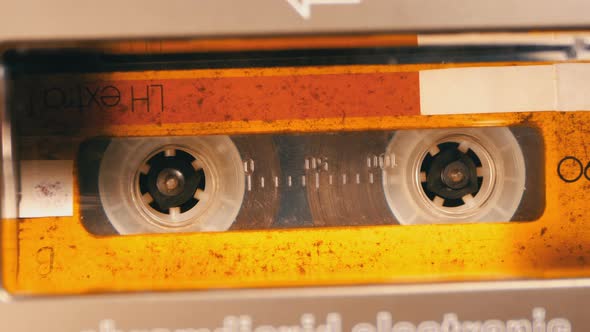 Vintage Yellow Audio Cassette in the Tape Recorder Playing and Rotates alt