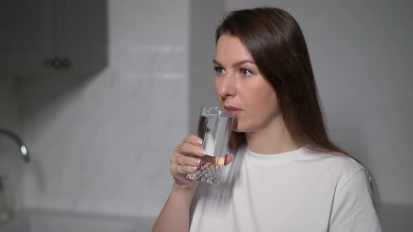 A Young Woman is Holding a Glass of Clean Water