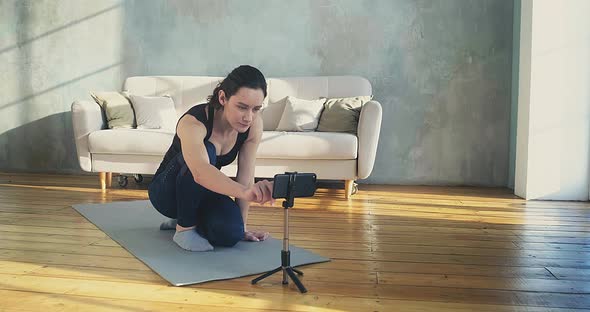 Pretty Woman Blogger Turns on Camera on Phone Put on Tripod alt