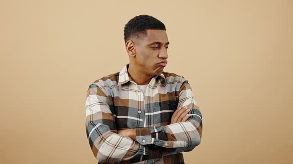 Young Upset African American Man Feeling Offended Pouting Lips and Crossing Arms Beige Studio alt