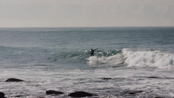 A surfer in a wetsuit making turns on a small wave near Bondi Beach Australia alt