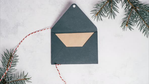 Stop Motion Video of Green Opening Envelope on White Background with Branches of Christmas Tree