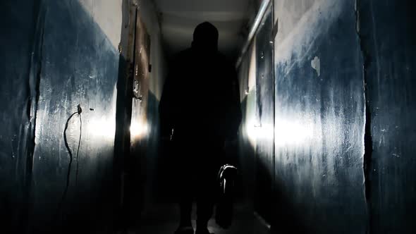 Silhouette of Unrecognizable Criminal Man Wearing Black Jacket and Carrying a Bag  alt