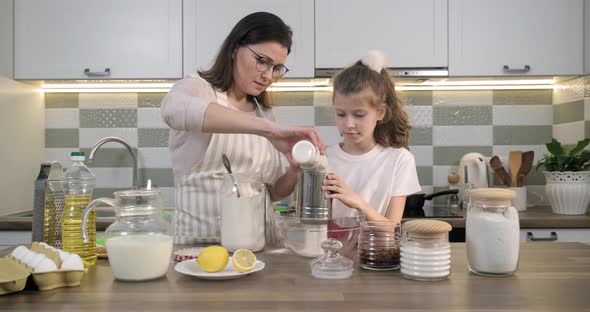 Mother and Child Preparing Bakery Together in Home Kitchen alt