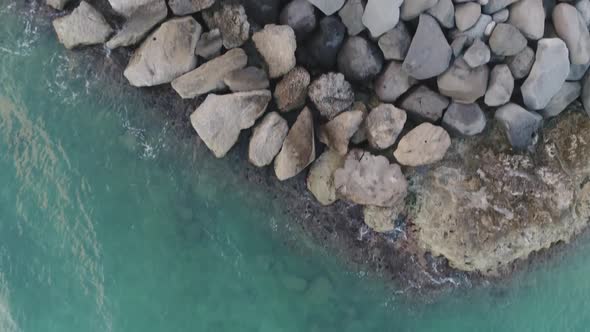 Topdown view turquoise water rocky pontoon, and green vegetation, Ko Olina Beach alt