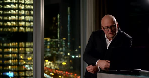 Bald Businessman Is Working at a Computer Near a Window. He Gets Upset About the Information, Takes alt