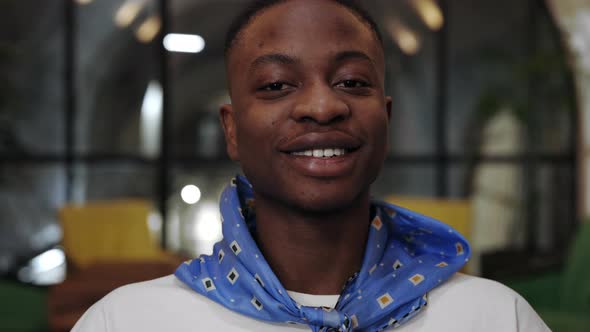 Close Up View of Young Positive Afro American Guy Looking to Camera and Smiling Broadly alt