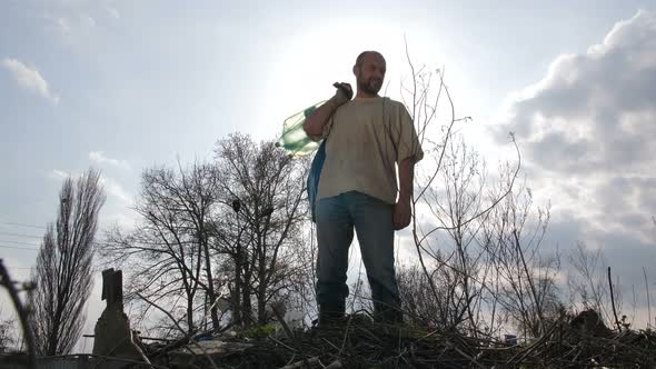 Man Climbing the Hill of Garbage at Dump Site alt