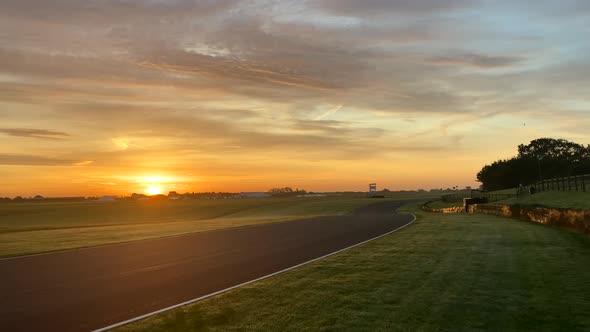 Sunrise shot of a motor race circuit in rural countryside. Camera panning alt
