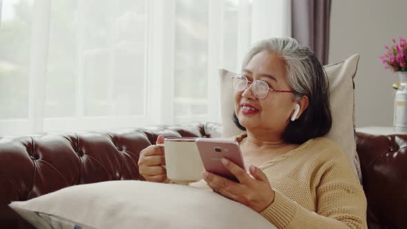 Senior woman listening music with happiness at home alt