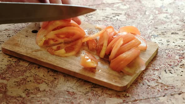  Man's Hands Cutting Tomatoes on a Wood Board in Kitchen Table.