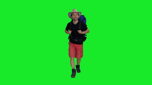Hiker in Cowboy Hat, Black T-shirt and Red Shorts Walking with Backpack on Green Screen